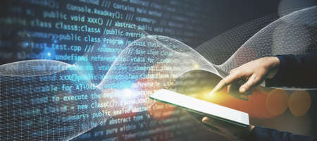 Close up of man hand pointing at tablet on abstract glowing blue tech background. Innovation and...