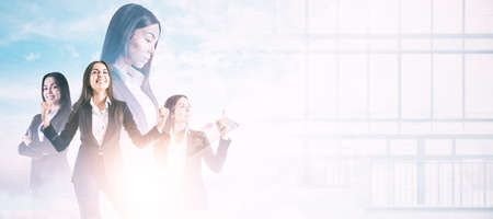 Businesswomen working together on bright white city background with mock up place. Teamwork and success concept. Double exposureの写真素材