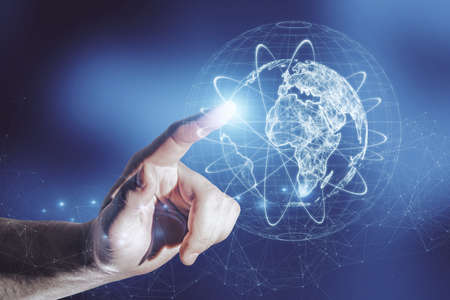 Close up of businessman hand pointing at abstract glowing globe hologram on blurry blue background....