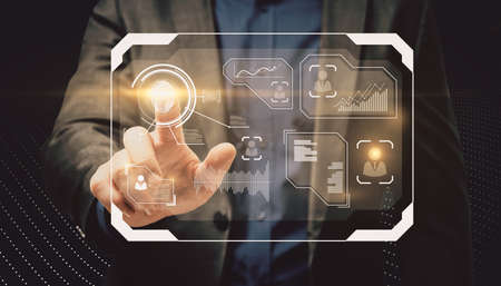 Businessperson hand pointing at abstract glowing finger print security interface on dark background....
