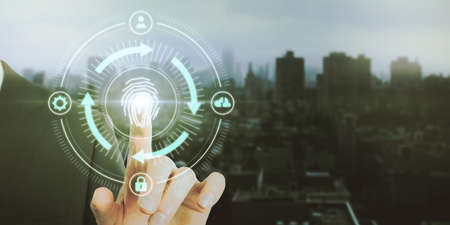 Close up of male hand pointing at abstract glowing fingerprint id scanning interface on blurry city...