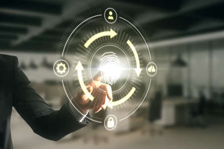 Close up of man hand pointing at abstract glowing fingerprint id scanning interface on blurry office...