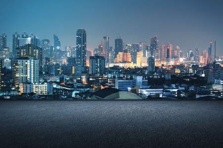 Concrete rooftop with night city view and mock up place for your advertisement. Beautiful background. Downtown and urban conceptの写真素材