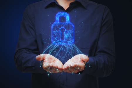 Close up of man hands holding glowing blue padlock hud on dark background. Safety, web security and future conceptの写真素材