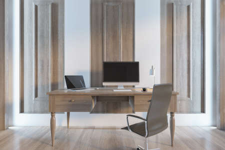 Antique wooden desk with blank computer and laptop screens, table lamp, coffee cup and other items....