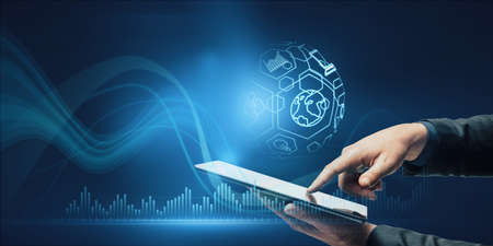 Close up of businessman hand pointing at tablet with creative spherical business interface on blue...
