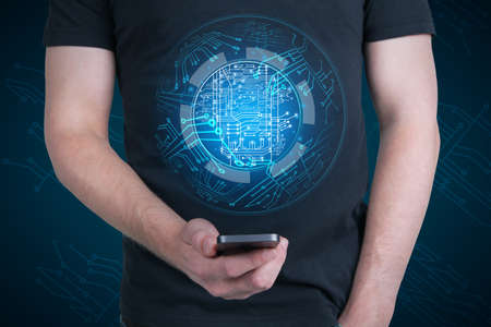 Close up of guy hand holding smartphone with abstract glowing digital circuit sphere on blue background. Hardware, technology and innovation conceptの写真素材