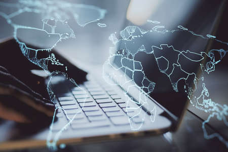 Close up of hands using laptop with creative glowing map on blurry background. Technology,...