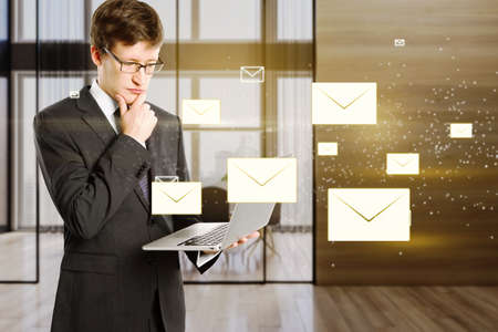 Attractive young european businessman using laptop with c creative glowing letters interface on...