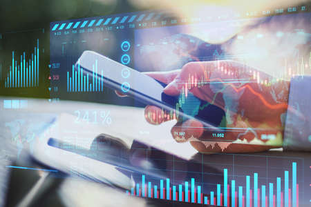 Close up of hand holding cellphone with glowing forex chart trading interface on blurry outdoor...