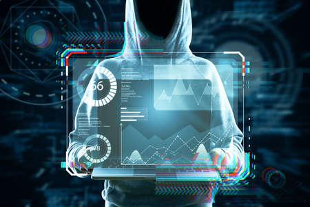 Hacker holding laptop with abstract glowing business hologram interface on dark background....