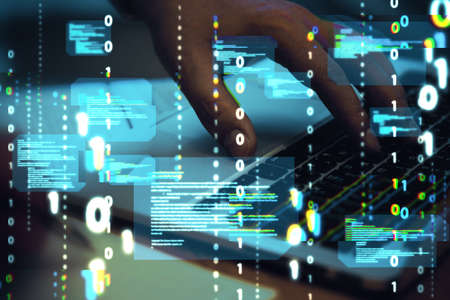Close up of hands using computer keyboard with abstract coding binary code hologram on blurry...
