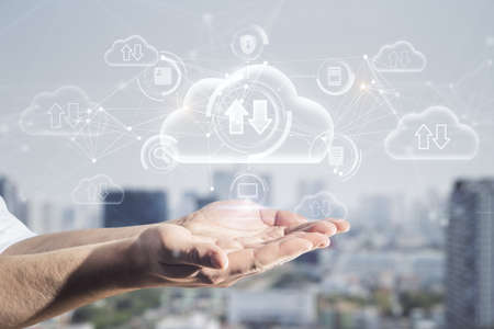 Close up of hands holding abstract glowing cloud computing hologram with download / upload arrows on...