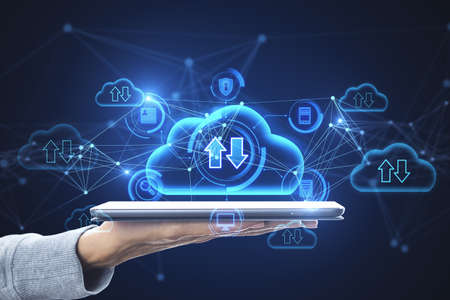 Close up of hand holding tablet with abstract glowing cloud computing hologram with download /...