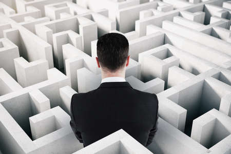 Back view of businessman in suit looking at white maze. Solution and challenege conceptの写真素材