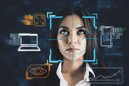 Portrait of attractive young european business woman with abstract glowing face recognition interface. Technology and security concept. Double exposureの写真素材