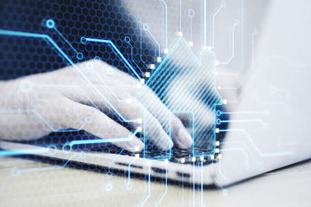 Close up of hands using laptop keyboard with abstract glowing house chip hologram on blurry...