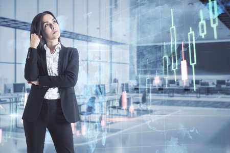 Thoughtful young European businesswoman standing on blurry office interior background with creative...