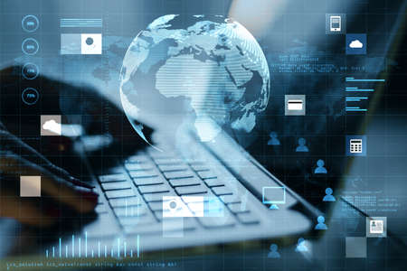 Close up of hands using laptop on desktop with abstract digital social globe grid hologram on blurry...