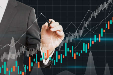 Businessman hand pointing at dark candlestick forex chart on blurry grid background. Trade, finance...