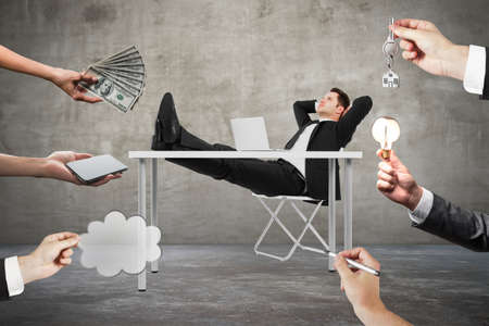 Abstract image of hands offering money, ideas, keys, lamps and devices to relaxing young businessman...