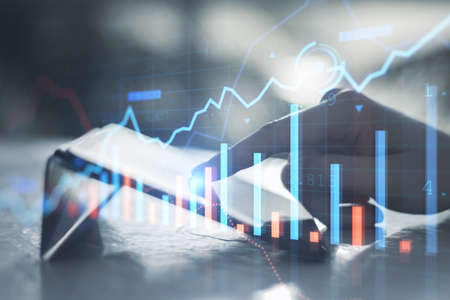 Close up of businessman hand pointing at tablet on desktop with creative glowing forex chart on...