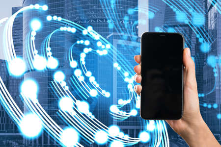 Close up of hand holding empty mock up smartphone with creative circular light blurry city...