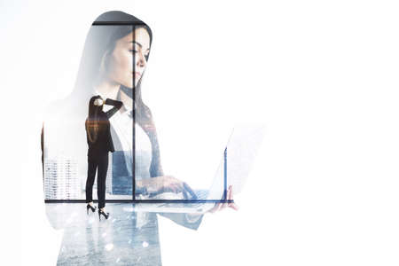 Portrait of attractive thoughtful european businesswoman using laptop on bright city office view background with mock up place. Technology, communication and success concept. double exposureの写真素材