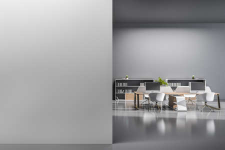 Contemporary coworking office interior with furniture, equipment, computer monitors and blank mock up place on concrete wall. 3D Renderingの写真素材