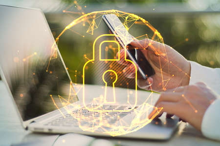 Close up of businessman hands using laptop and smartphone with abstract glowing polygonal sphere...