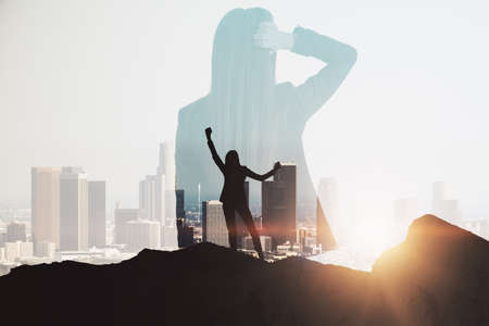 Thoughtful successful businesswoman on mountain top. Leadership and future concept. Abstract city...