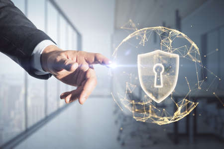 Close up of businessman hand pointing at abstract glowing polygonal sphere with glowing digital padlock shield on blurry office interior background. Safety, protect and technology concept. double exposureの写真素材