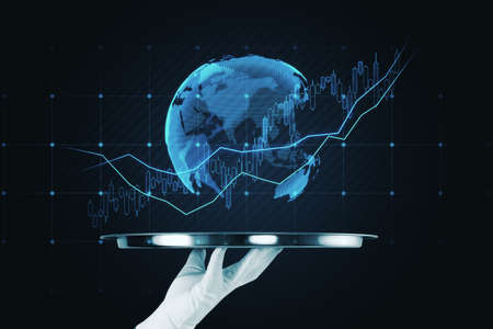 Close up of hand holding tray with glowing global candlestick forex chart on dark background. Trade, finance and stock conceptの写真素材