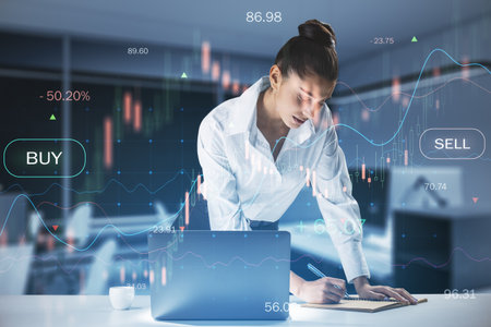 Attractive caucasian businesswoman working at desktop with laptop and glowing business chart on...