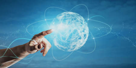 Close up of businessman hand pointing at abstract polygonal sphere on blue background. Metaverse and...