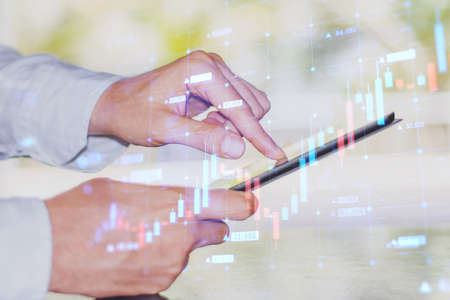 Close up of businessman hand using cellphone with abstract growing forex chart on blurry outside...