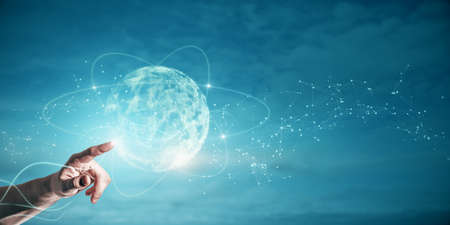 Close up of businessman hand pointing at abstract polygonal sphere on blue background with mock up...
