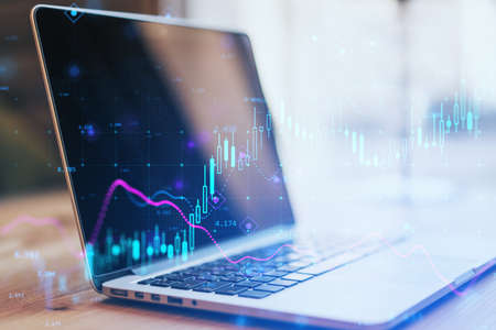 Close up of laptop with glowing forex chart on blurry background. Fintech, digital transformation...