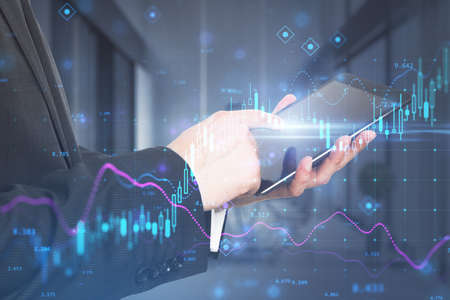 Close up of businessman hand using tablet while standing in blurry office interior with glowing...