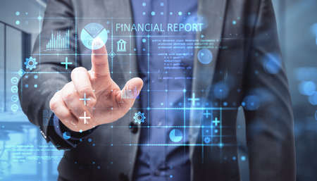 Close up of businessman hand pointing at abstract glowing blue financial report hologram on blurry...