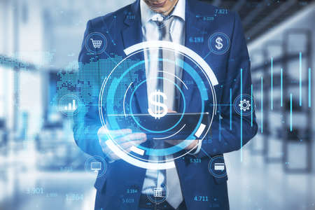 Close up of businessman hand holding tablet with creative glowing round dollar chart hologram on...