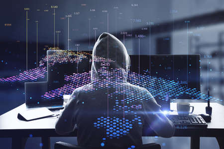 Back view of hacker using computers at desktop with abstract digital map and index lines on blurry...