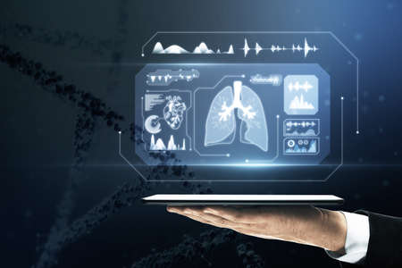 Close up of businessman hand holding tablet with glowing medical hologram. Health care and digital transformation concept. Blurry dna helix in the backgroundの写真素材