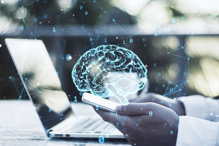 Close up of businessman hands using laptop and smartphone with creative polygonal brain hologram on...