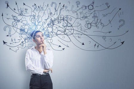 Portrait of attractive thoughtful young european businessman standing on concrete wall background with arrows mesh sketch. Confusion and question conceptの写真素材