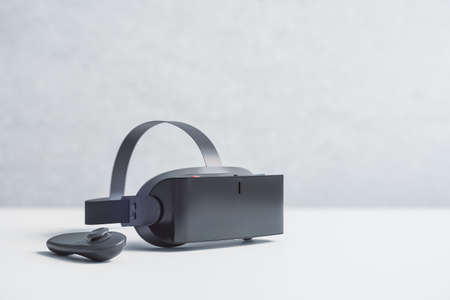 Virtual reality and metaverse concept with black VR headset and joystick on white table surface. 3D renderingの写真素材