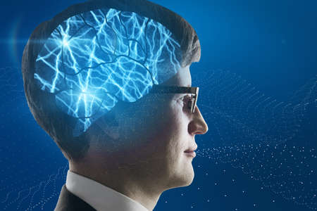 Portrait of attractive young european businessman with abstract shiny blue digital brain hologram on dark background. Human technology, research and science concept. double exposureの写真素材