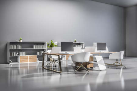Modern spacious office hall with white coworking places and shelves decorated by wood on gray glossy floor. 3D renderingの写真素材