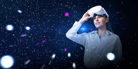 Abstract double exposure image of smiling young white european woman with VR glasses on starry sky...