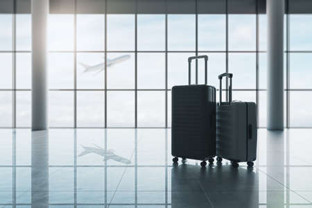 Travel and vacation concept with hand luggage suitcase and big one on glossy empty airport building floor and plane taking off outside waiting area window. 3D renderingの写真素材